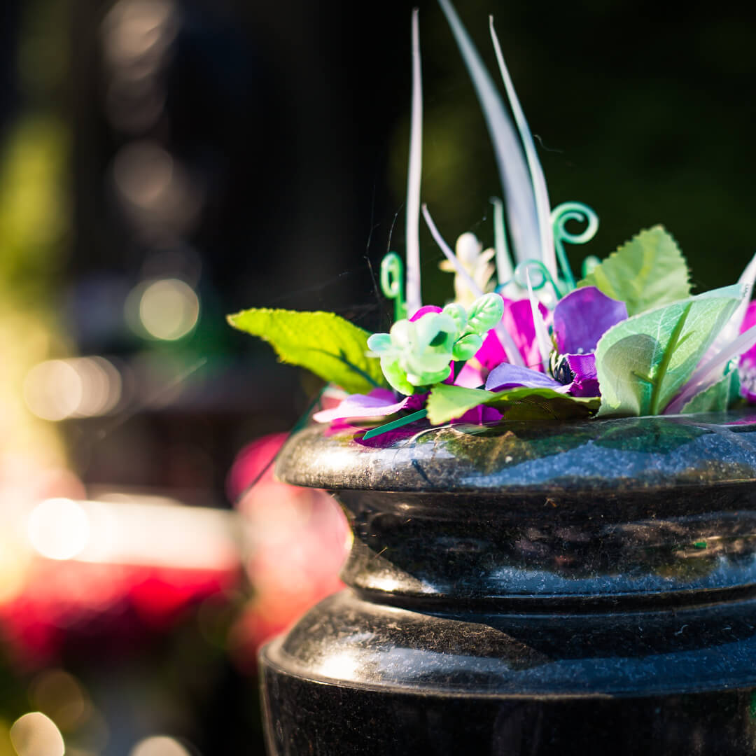 Ваза на кладбище с искусственными цветами